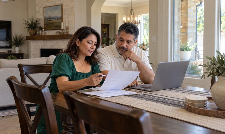 Couple comparing Irving home insurance quotes with a laptop and coverage paperwork